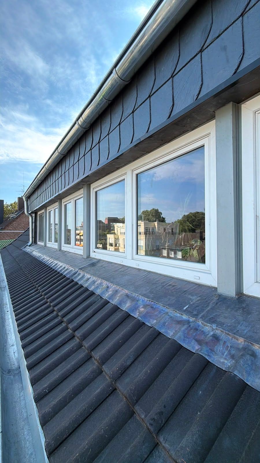 Zinkeinfassung entlang einer Fensterfront im Dach